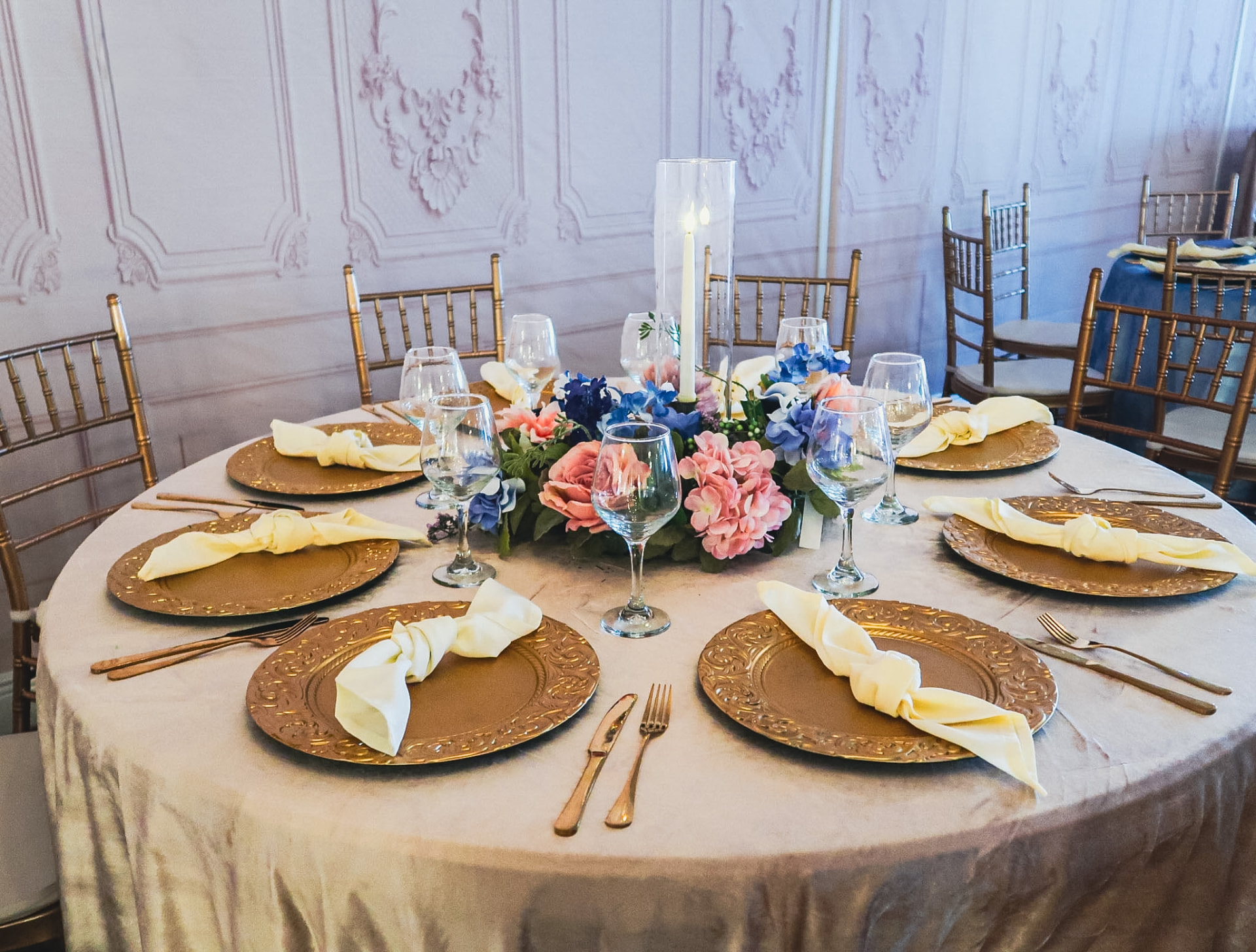 Champagne velvet table with pink and blue florals and a taper candle