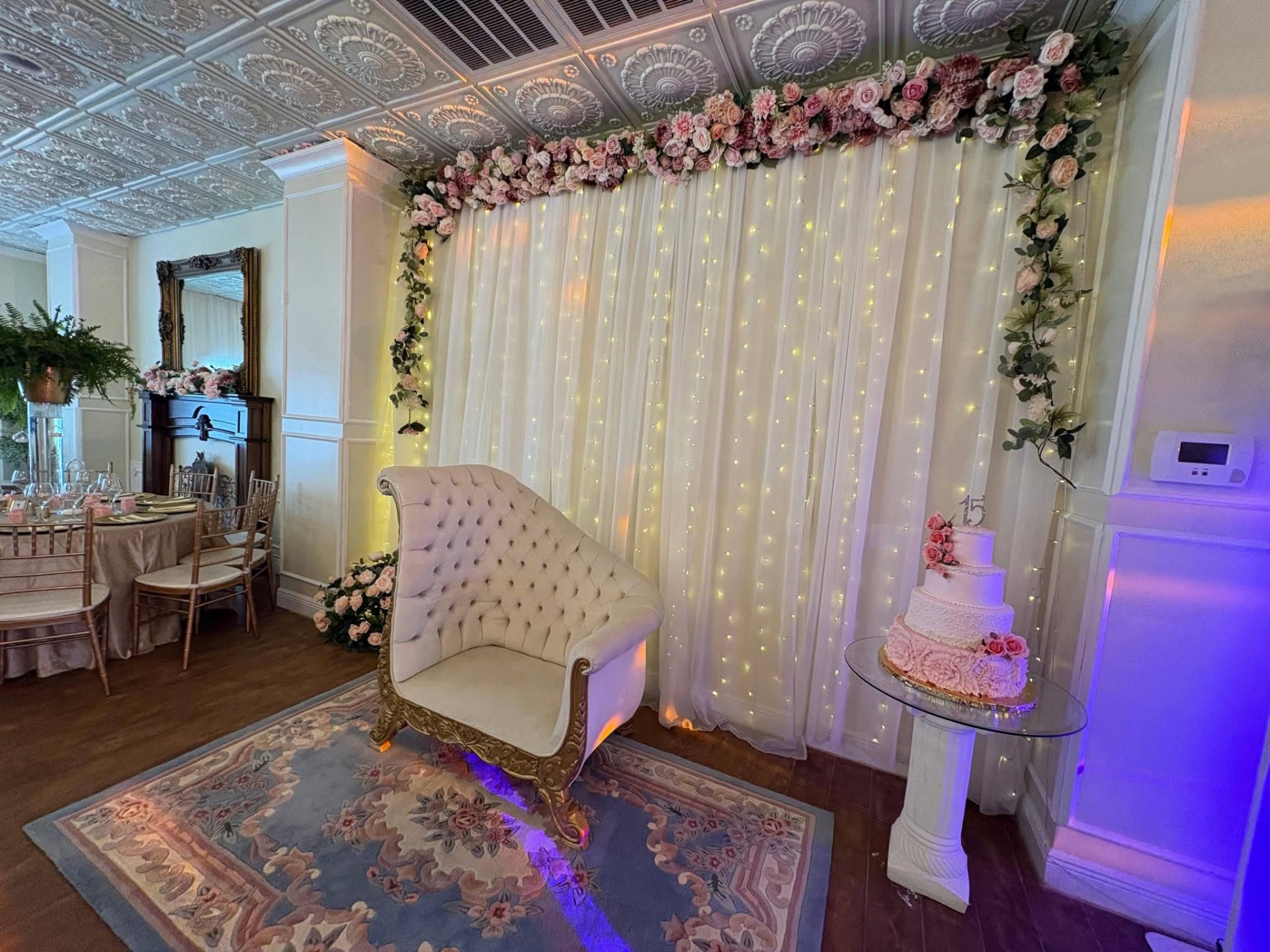 Sweetheart backdrop with floral garland and tiered cake
