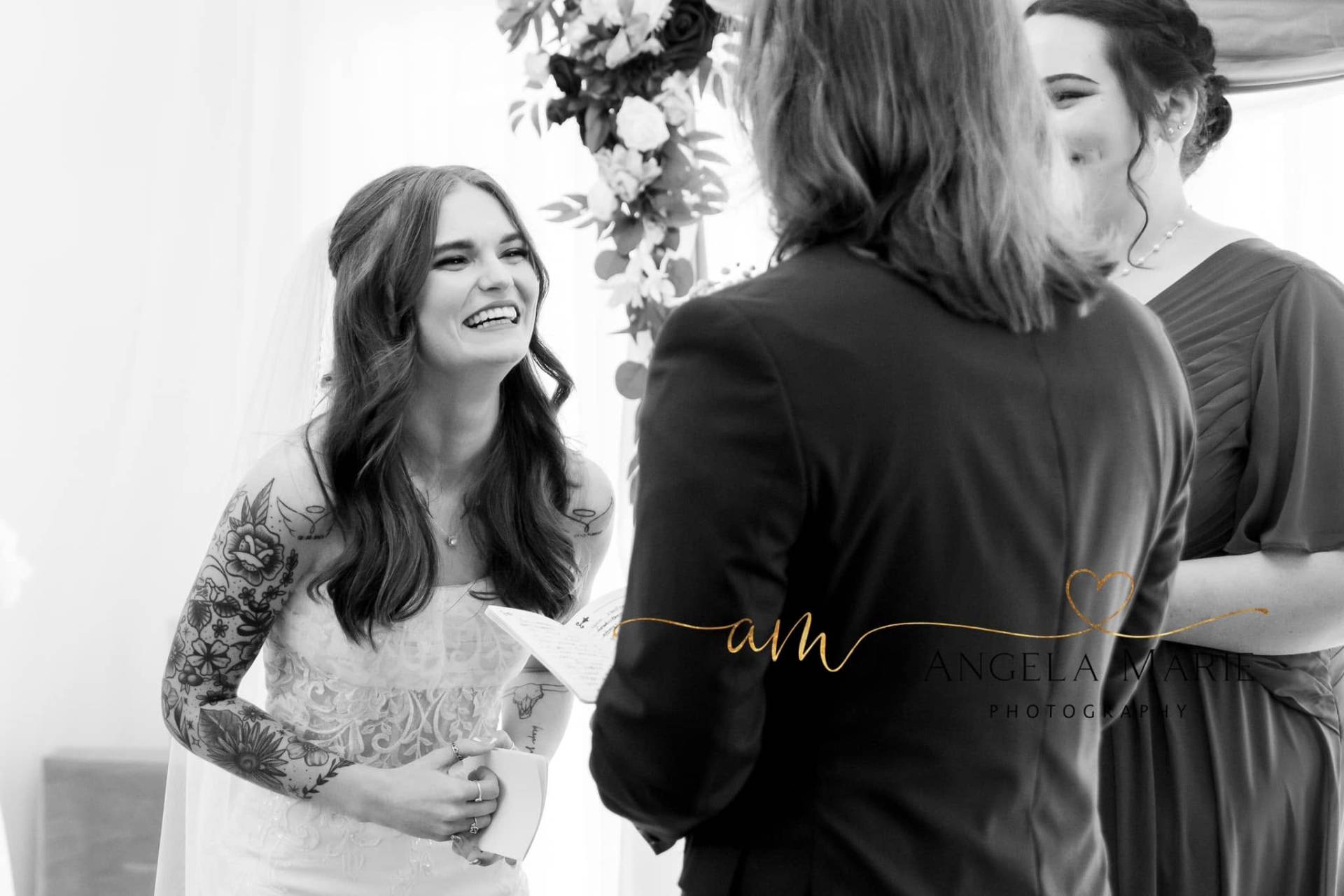 Black and white portrait of bride laughing during ceremony