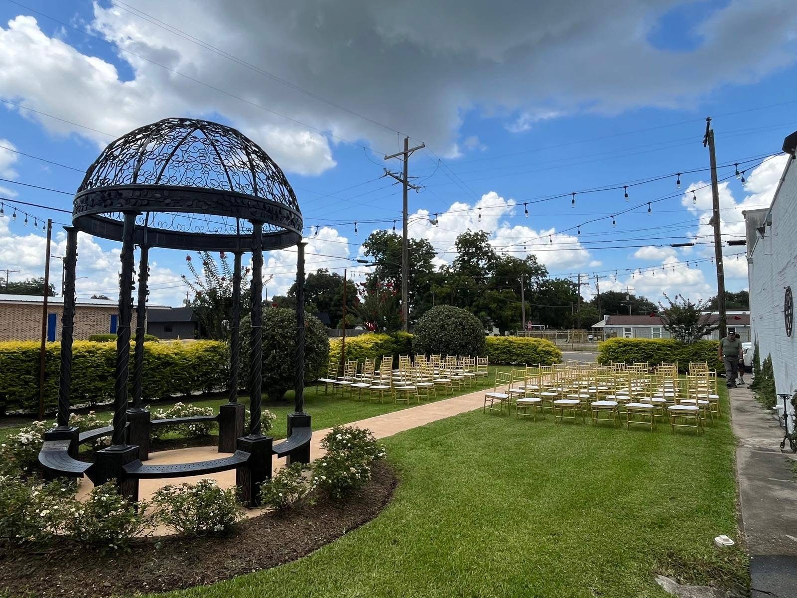 Outdoor ceremony space with wrought iron gazebo and string lights